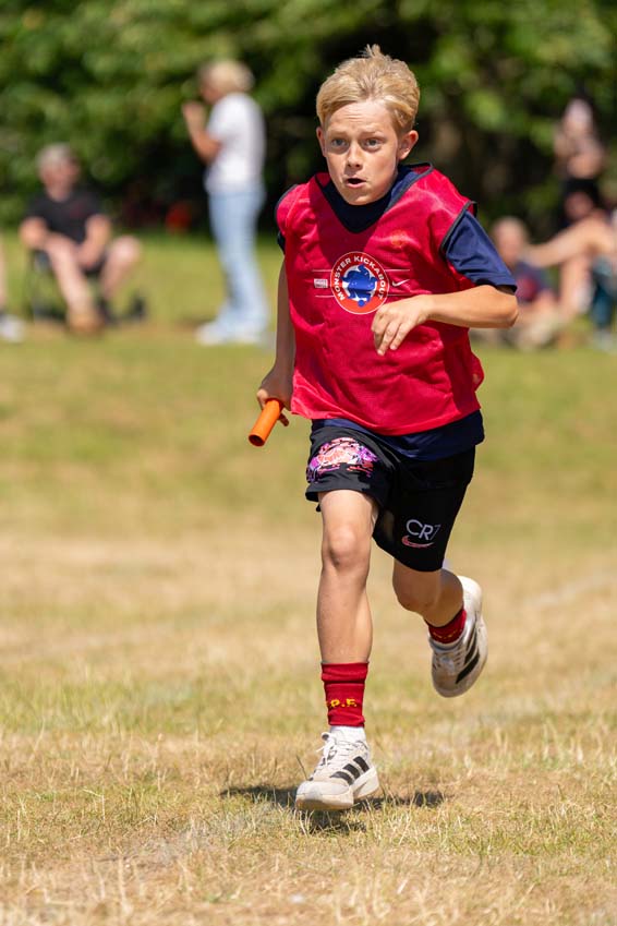 Primary school relay race with a boy carrying his batton at SMSJ's sports day