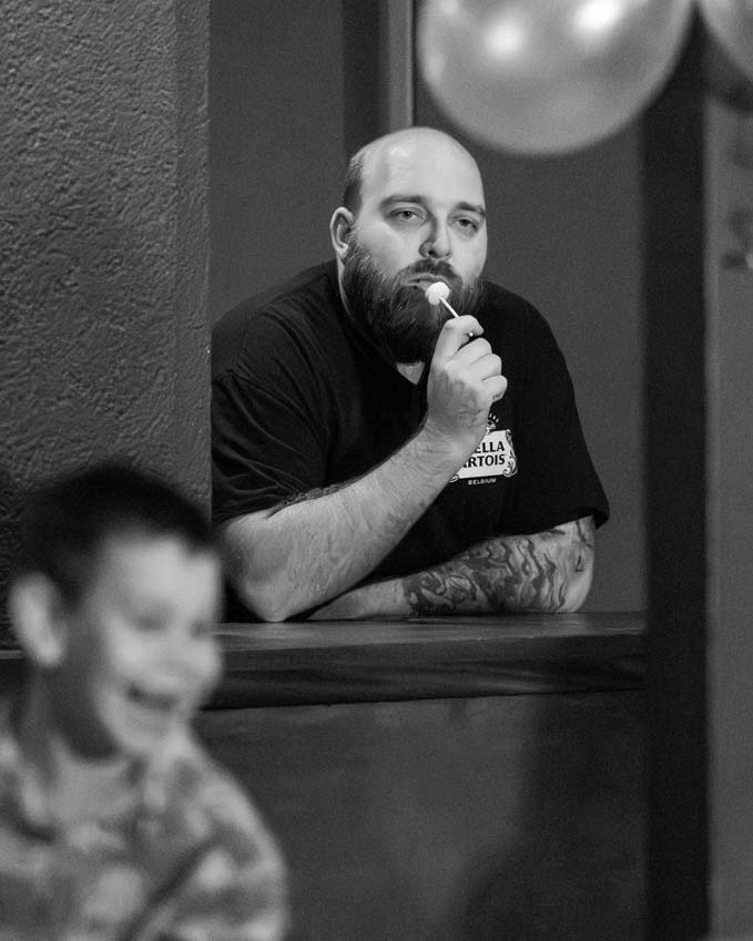 A bartender chilling out with a lolly waiting for customers