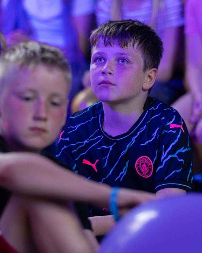 A boy lost in a thoughtful moment at his primary school leavers presentation evening