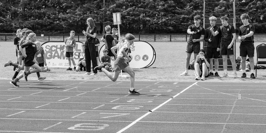 Primary school Olympics day held at the Corby athletics stadium with sports leaders photographed carefully timing on the finish line