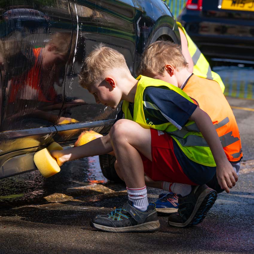 SMSJ Primary School hand car wash fundraiser boys scrubbing attentively