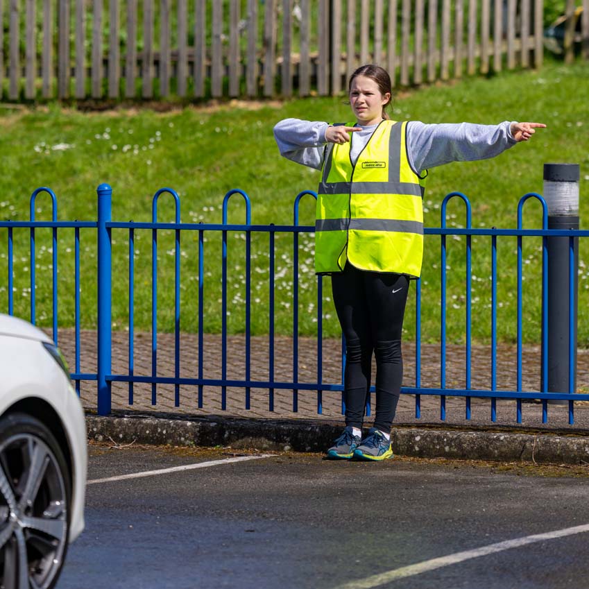 SMSJ Primary School hand car wash fundraiser directing traffic sternly