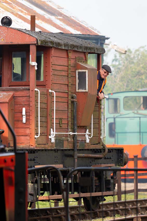 Train guard enjoying the ride looking out from the brake van at Rocks by Rail Rutland